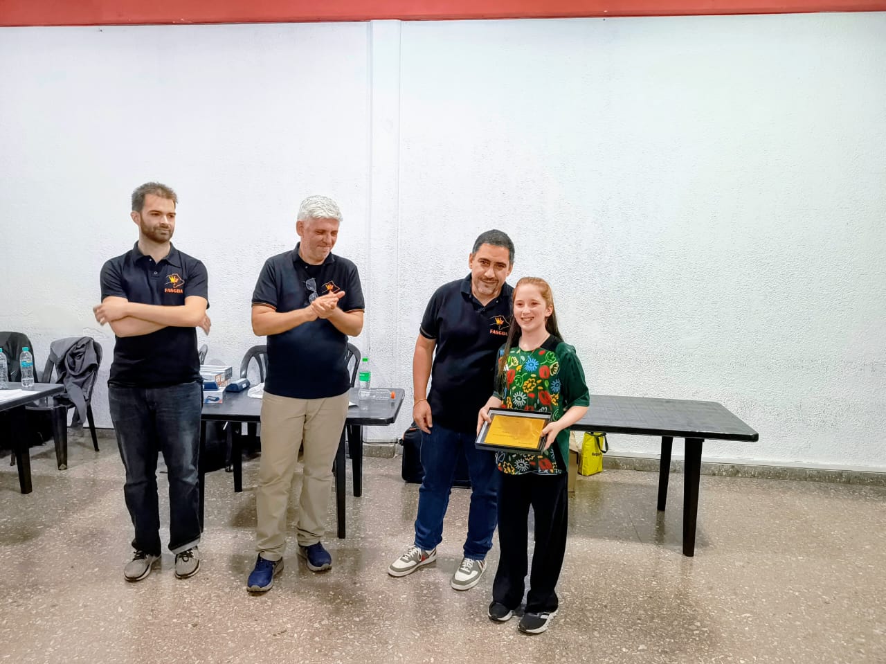 Isabella Yacomini posando con su plaqueta con las autoridades de Fasgba: Juan Francisco Queimaliños (Tesorero), Marcelo Re (Secretario General) y Alejandro Méndez (Presidente)